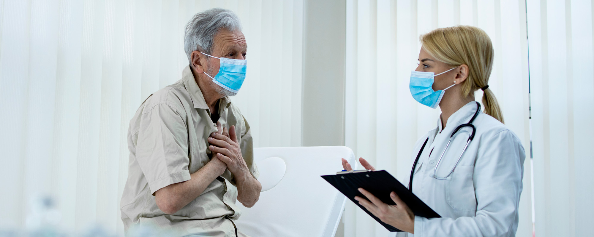 elderly man complaining on chestpains while doctor writing down symptoms