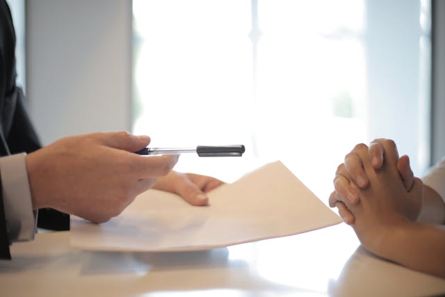 people looking at documents and pen