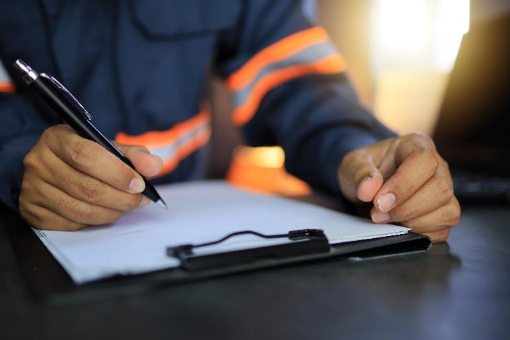 railroad worker filling out paperwork on a clipboard